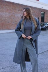 a lady in a grey knit top, a grey wool coat and a pair of grey pants
